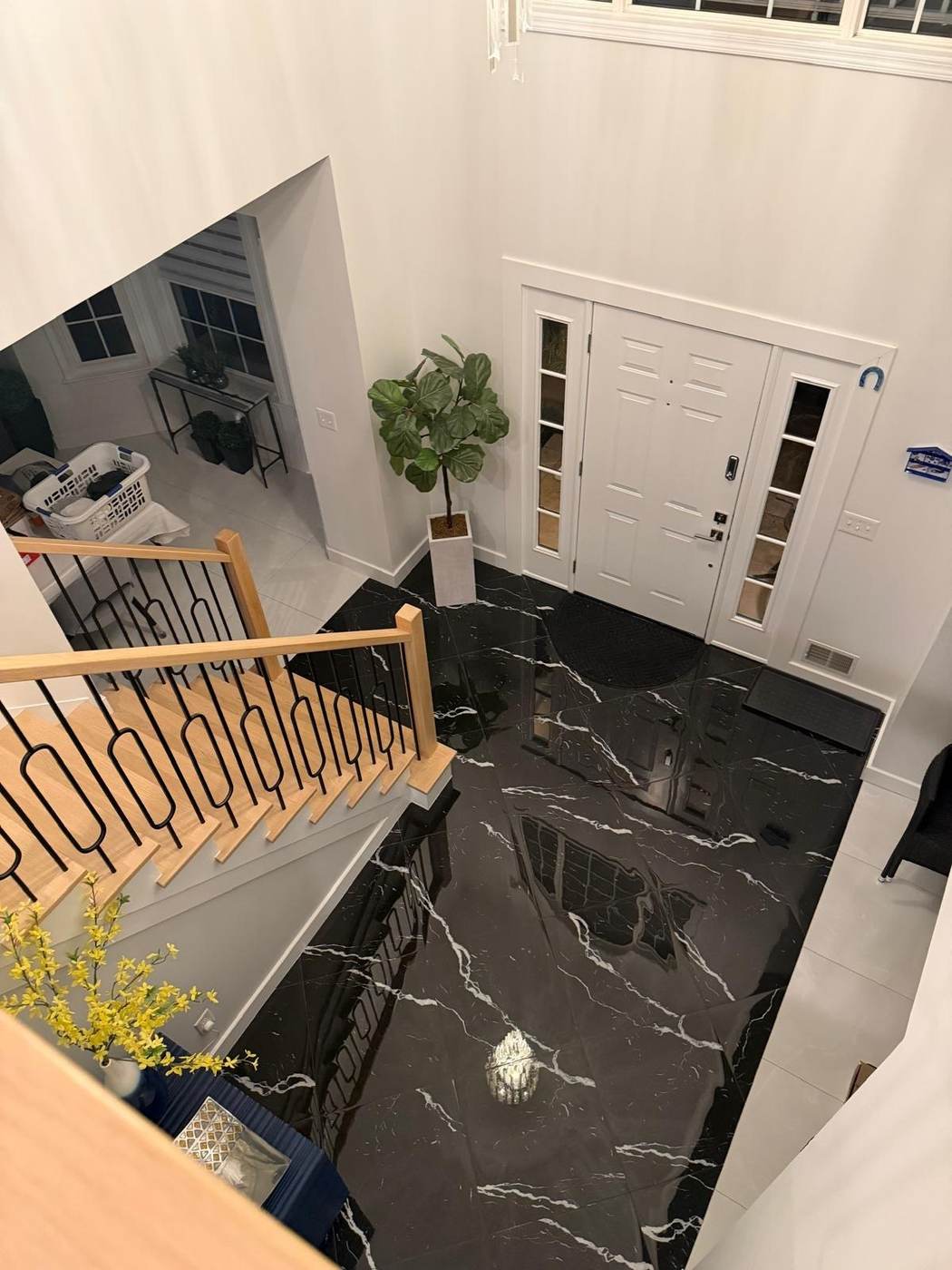 Wood stair above a black marble foyer floor