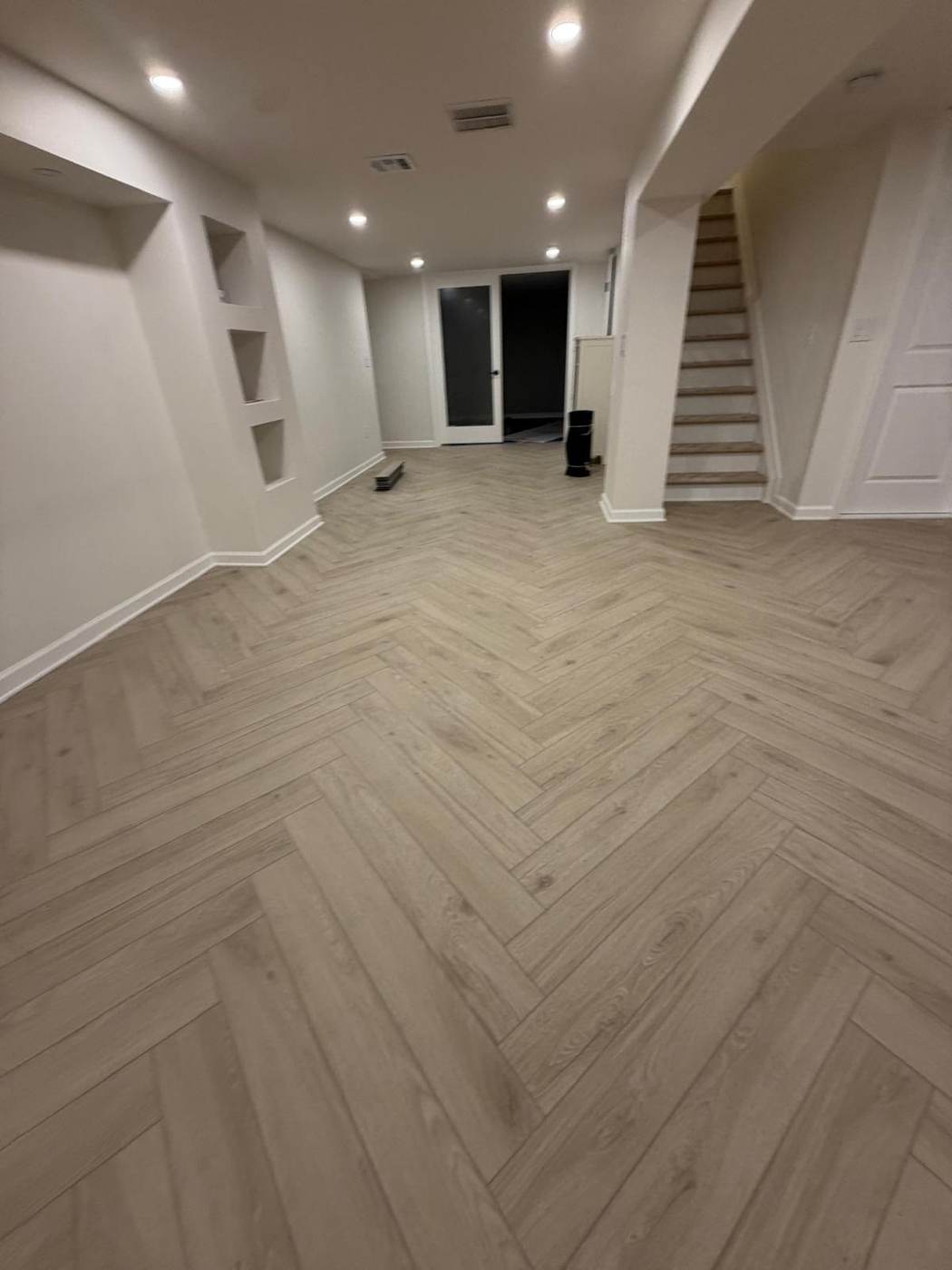 Light herringbone-pattern plank floor in a finished basement
