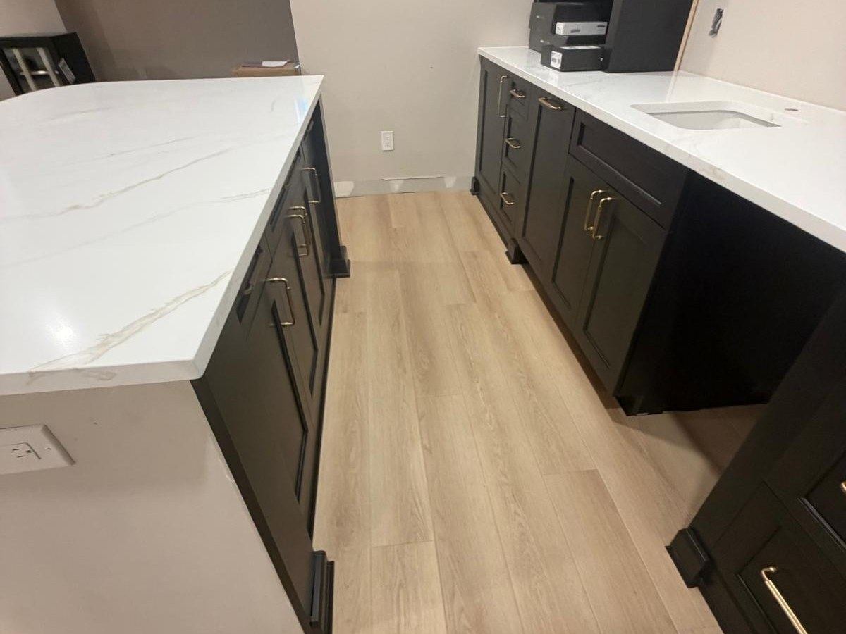 Light vinyl plank floor beside a white countertop island